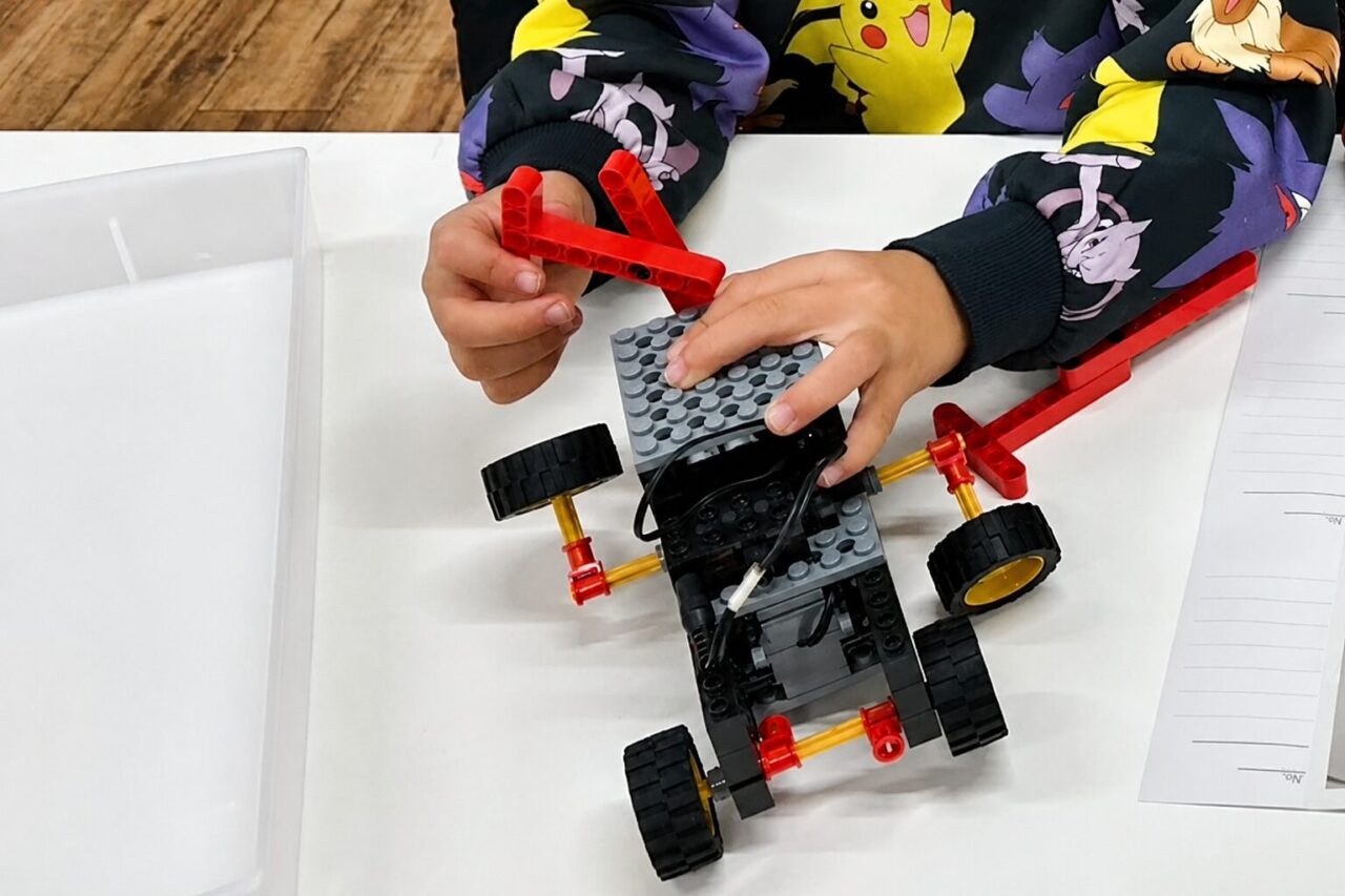 ロボット教室でブロックパーツを使ってロボットを組み立てている子どもの手元
